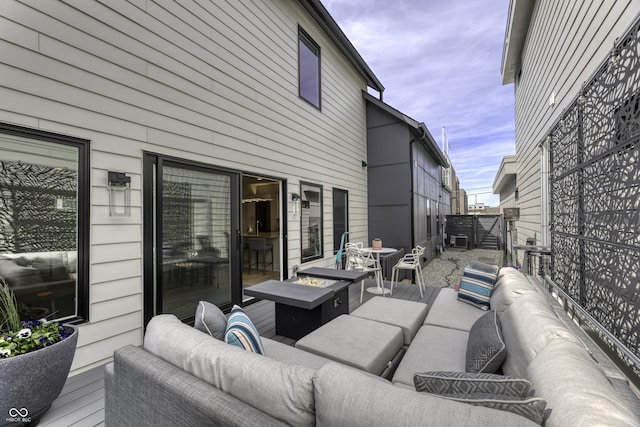 exterior space featuring fence, an outdoor living space with a fire pit, and a deck