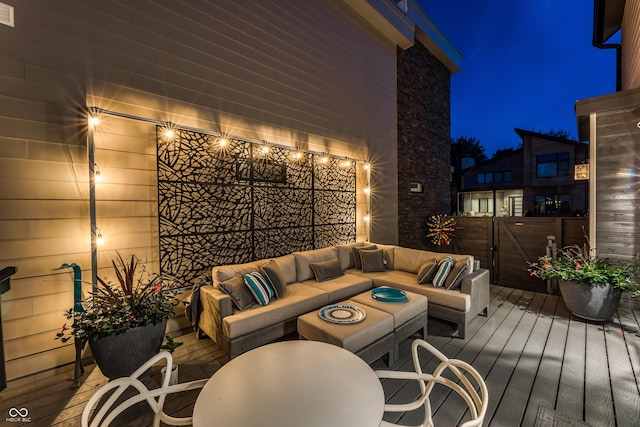 deck at night featuring outdoor lounge area