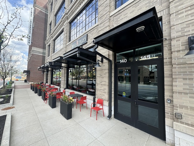 property entrance featuring french doors and brick siding