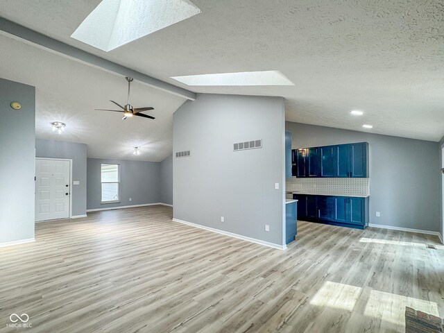 9362 Helmsdale Dr, Indianapolis, IN 46256 - unfurnished living room with vaulted ceiling with skylight, light wood-type flooring, and visible vents