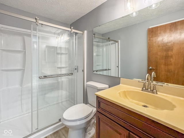9362 Helmsdale Dr, Indianapolis, IN 46256 - bathroom featuring a shower stall, wood finished floors, toilet, vanity, and a textured ceiling