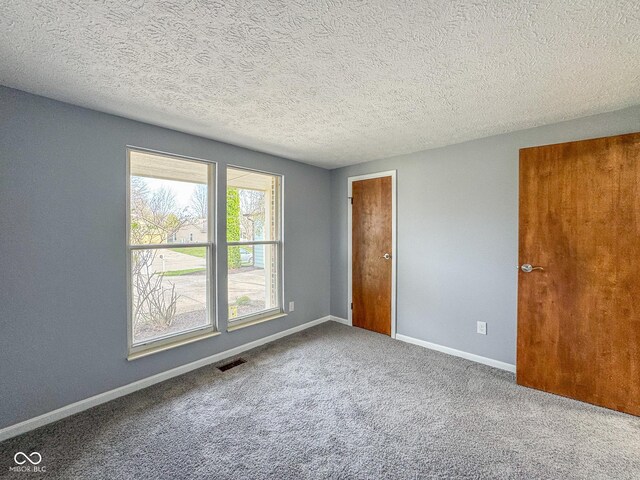 9362 Helmsdale Dr, Indianapolis, IN 46256 - empty room with baseboards, visible vents, carpet, and a textured ceiling