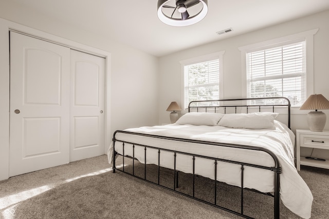 bedroom featuring carpet floors, visible vents, and a closet