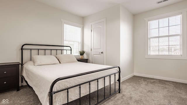 bedroom featuring baseboards, light colored carpet, and visible vents