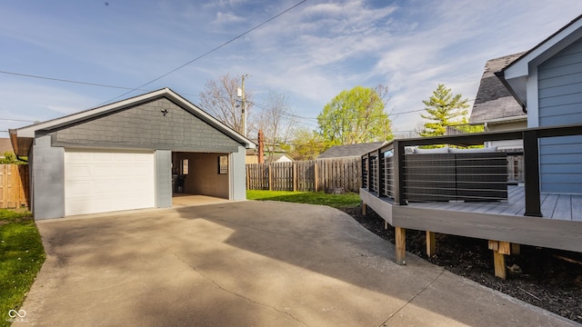 view of side of property with a detached garage, a deck, fence, and an outbuilding