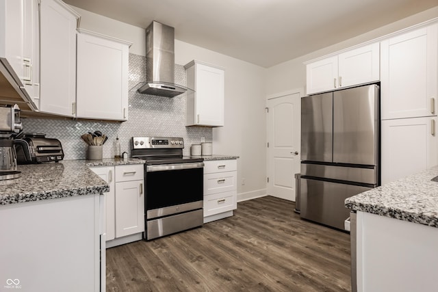 kitchen with decorative backsplash, wall chimney exhaust hood, white cabinetry, dark wood finished floors, and appliances with stainless steel finishes