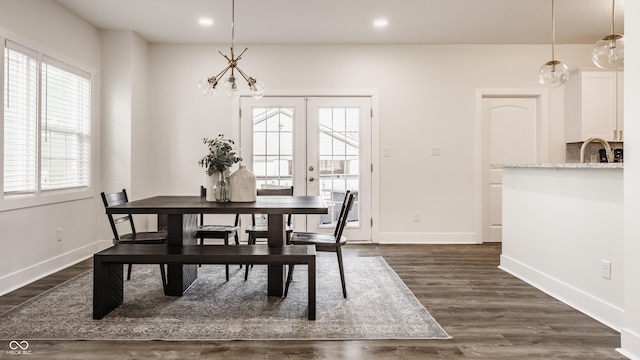 dining area featuring baseboards, a notable chandelier, and a healthy amount of sunlight