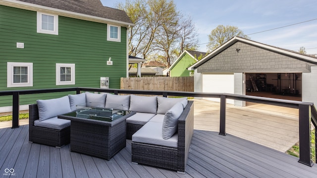 deck featuring a garage, an outdoor structure, and an outdoor living space