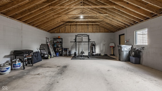 interior space featuring vaulted ceiling and concrete block wall