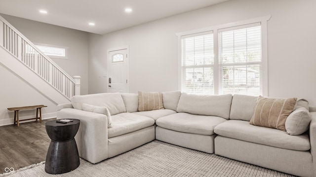 living room featuring recessed lighting, baseboards, wood finished floors, and stairway