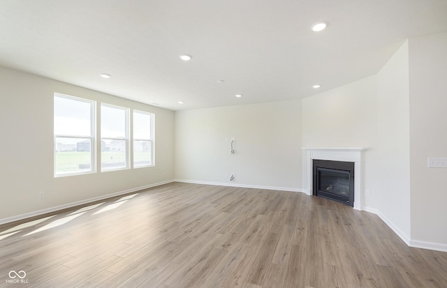 827 Allandale Ave, Westfield, IN 46074 - unfurnished living room featuring light wood finished floors, a glass covered fireplace, baseboards, and recessed lighting