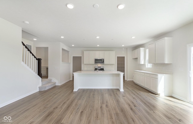 827 Allandale Ave, Westfield, IN 46074 - kitchen featuring appliances with stainless steel finishes, decorative backsplash, white cabinetry, light wood-style flooring, and recessed lighting