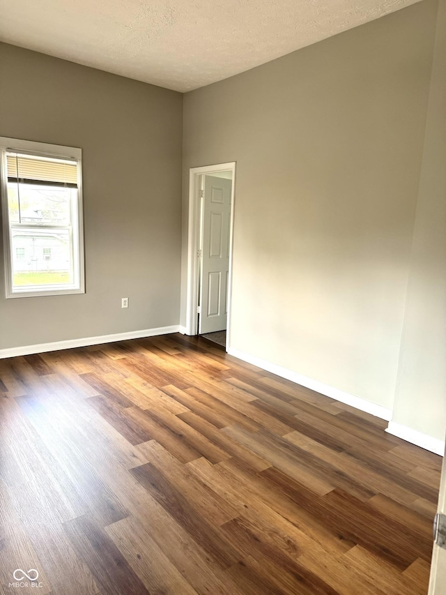3502 N Illinois St, Indianapolis, IN 46208 - empty room featuring dark wood-type flooring, a textured ceiling, and baseboards