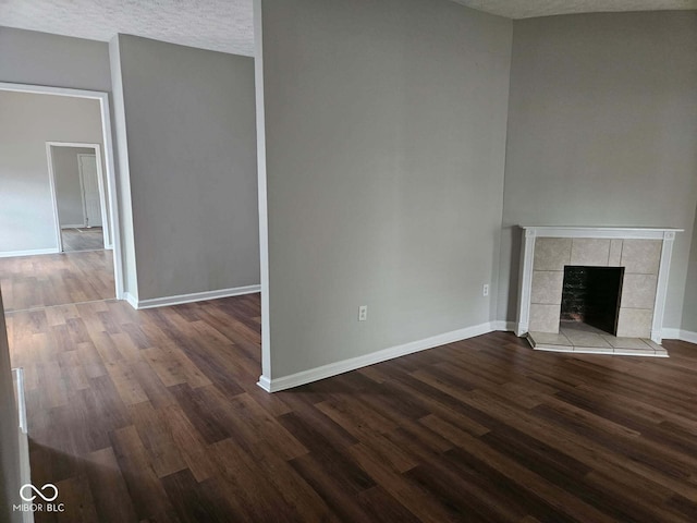 3502 N Illinois St, Indianapolis, IN 46208 - unfurnished living room with a fireplace, dark wood-type flooring, baseboards, and a textured ceiling