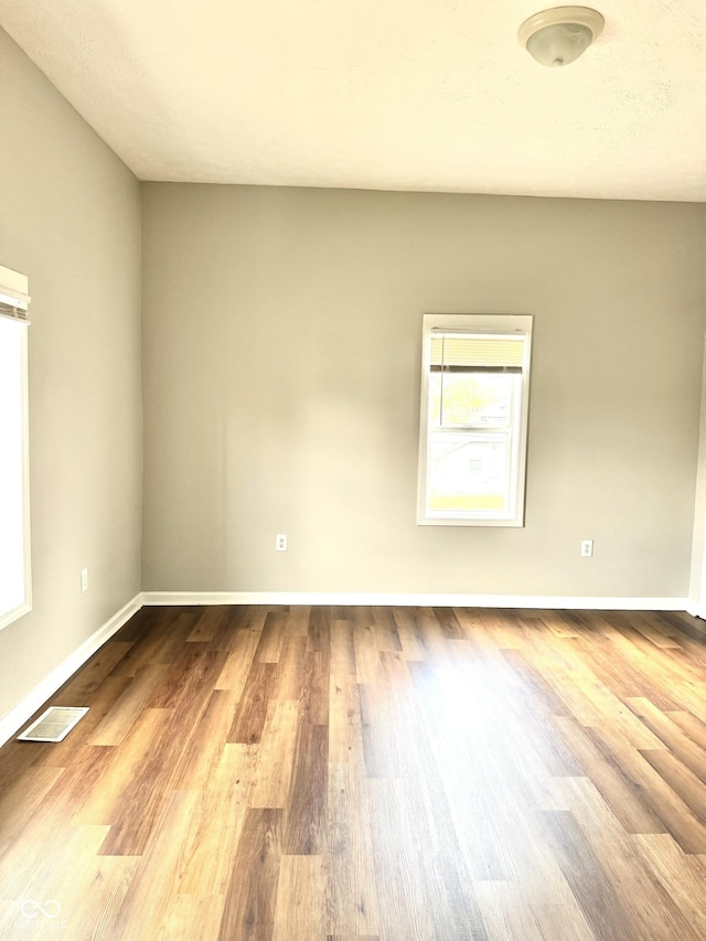 3502 N Illinois St, Indianapolis, IN 46208 - spare room featuring wood finished floors, baseboards, and visible vents