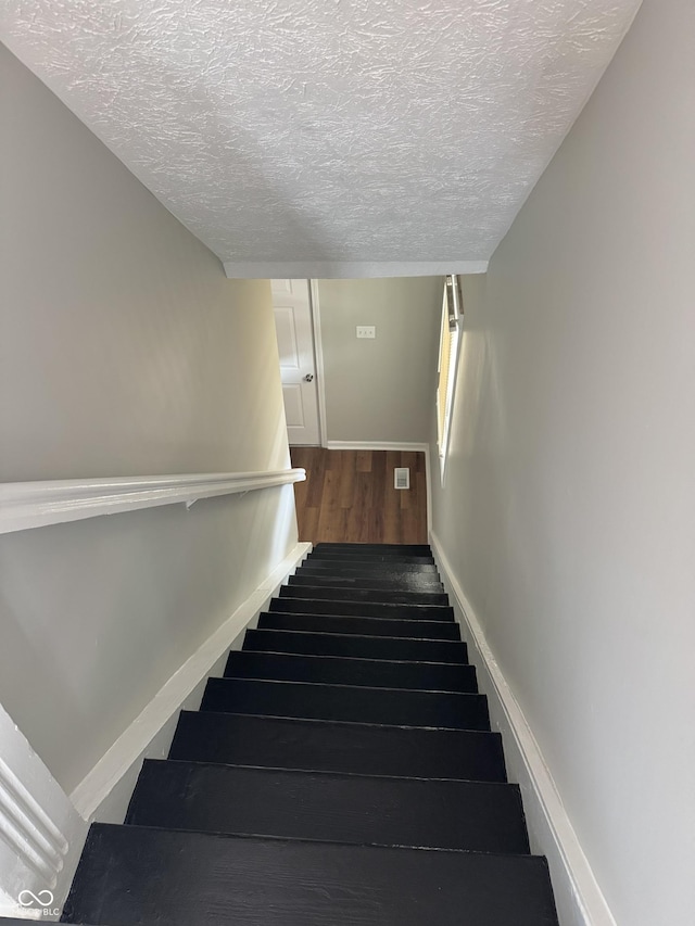 3502 N Illinois St, Indianapolis, IN 46208 - stairway featuring a textured ceiling, wood finished floors, and baseboards
