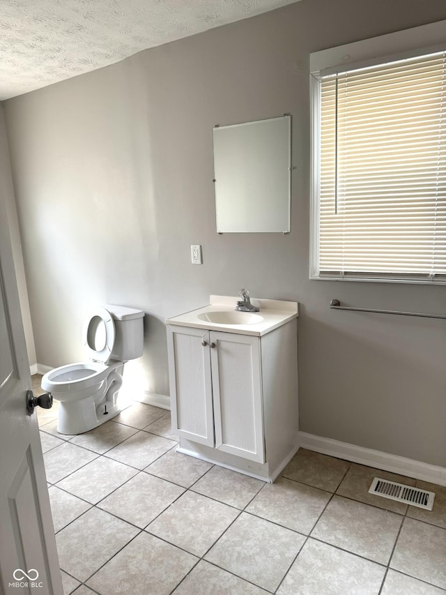 3502 N Illinois St, Indianapolis, IN 46208 - bathroom with visible vents, baseboards, toilet, a textured ceiling, and tile patterned flooring
