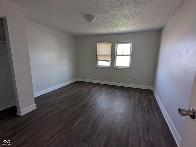 interior space with dark wood-style floors, a textured ceiling, and baseboards