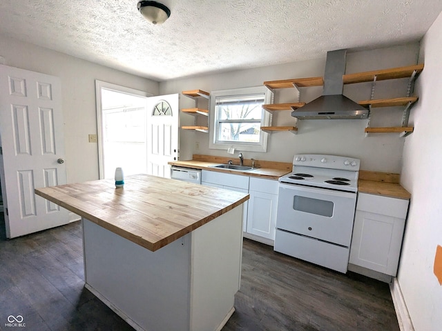 kitchen with wall chimney exhaust hood, white appliances, open shelves, a sink, and wood counters