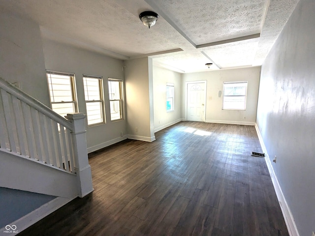 interior space with dark wood-type flooring, baseboards, stairs, and a textured ceiling