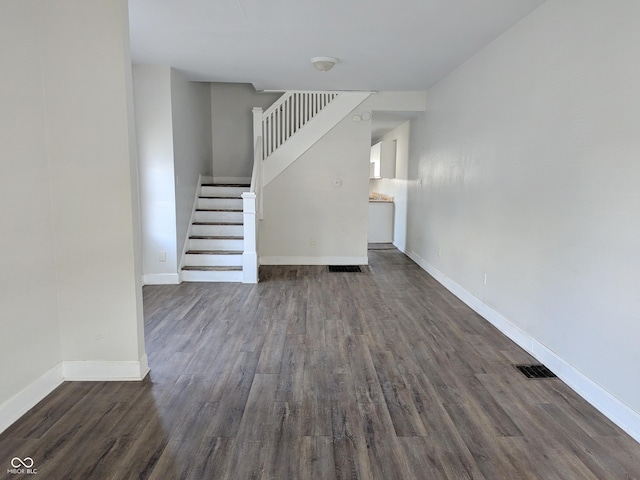 408 E Beecher St, Indianapolis, IN 46225 - unfurnished living room with stairs, dark wood finished floors, and baseboards