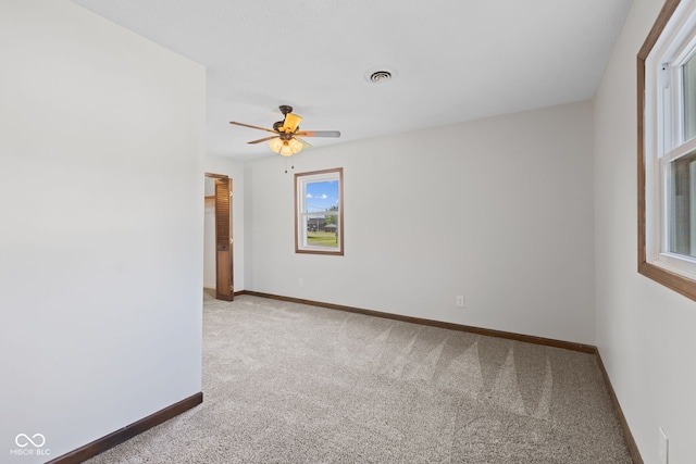 empty room with carpet, ceiling fan, and baseboards