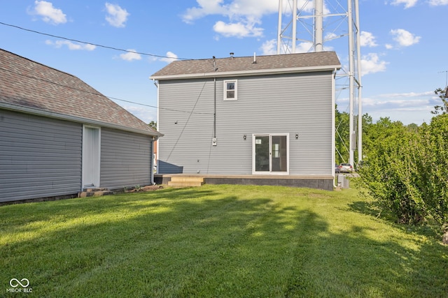 rear view of property with a yard and an outbuilding