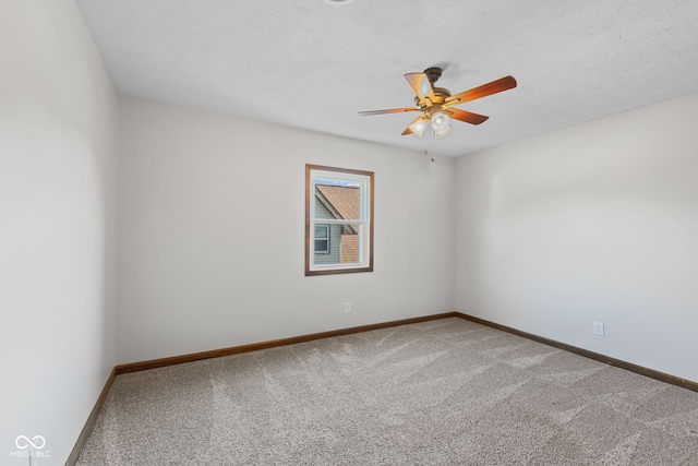 carpeted spare room with ceiling fan, baseboards, and a textured ceiling