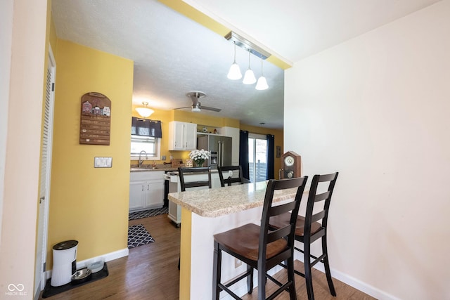 30 Sleepy Hollow Ct, Westfield, IN 46074 - kitchen featuring a kitchen bar, a sink, baseboards, a peninsula, and high end fridge