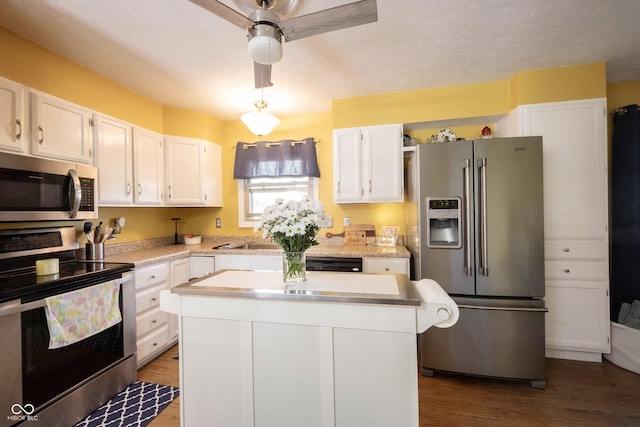 30 Sleepy Hollow Ct, Westfield, IN 46074 - kitchen with wood finished floors, light countertops, white cabinets, a ceiling fan, and stainless steel appliances
