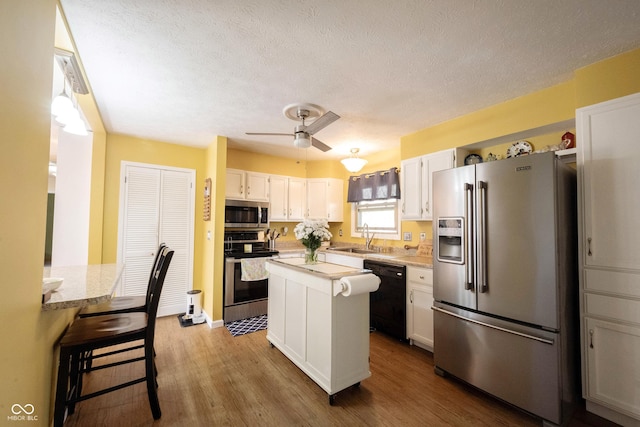 30 Sleepy Hollow Ct, Westfield, IN 46074 - kitchen featuring dark wood-style flooring, appliances with stainless steel finishes, a sink, white cabinetry, and a ceiling fan