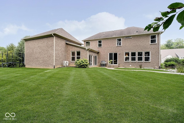 1060 Cape Coral Dr, Cicero, IN 46034 - rear view of house with cooling unit, a trampoline, brick siding, and a yard