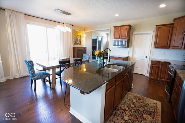 1060 Cape Coral Dr, Cicero, IN 46034 - kitchen with tasteful backsplash, a sink, brown cabinetry, dark stone counters, and stainless steel appliances