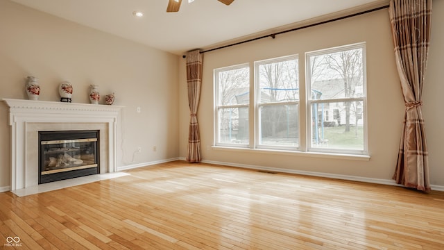 12561 Gladecrest Dr, Carmel, IN 46033 - unfurnished living room featuring a ceiling fan, light wood-style floors, a fireplace with flush hearth, healthy amount of natural light, and recessed lighting