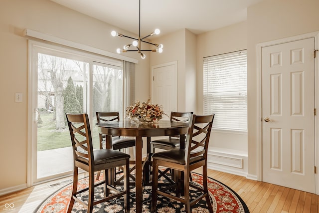 12561 Gladecrest Dr, Carmel, IN 46033 - dining area featuring light wood finished floors, a chandelier, and plenty of natural light