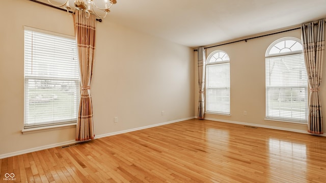 12561 Gladecrest Dr, Carmel, IN 46033 - empty room with a chandelier, light wood-style floors, and baseboards