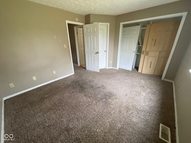 unfurnished bedroom with baseboards, carpet floors, visible vents, and a closet