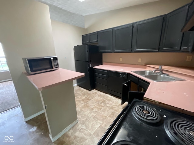 kitchen with a sink, black appliances, dark cabinetry, light countertops, and lofted ceiling