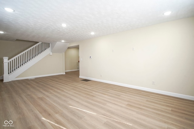 unfurnished living room with baseboards, recessed lighting, and stairs