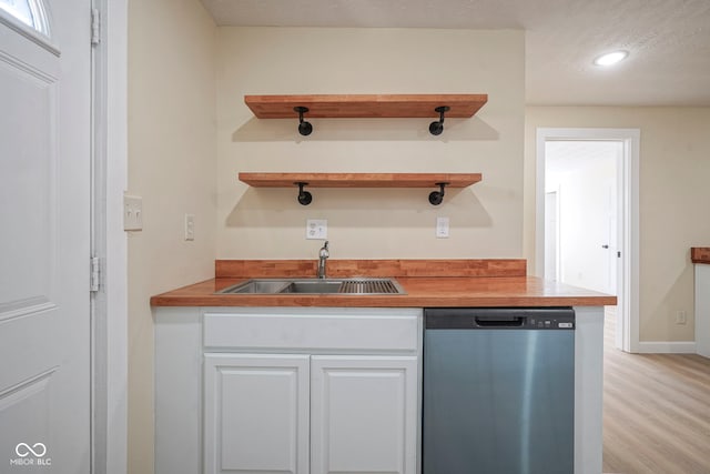 kitchen with a sink, light wood-style flooring, white cabinetry, recessed lighting, and stainless steel dishwasher