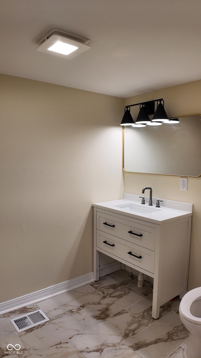 bathroom featuring vanity, visible vents, baseboards, and marble finish floor