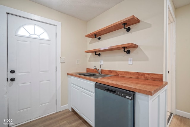 kitchen featuring open shelves, butcher block countertops, light wood-type flooring, a sink, and dishwasher