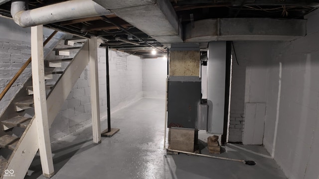 unfinished below grade area with heating unit and stairs