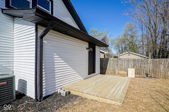 view of property exterior featuring central air condition unit, fence, and a deck