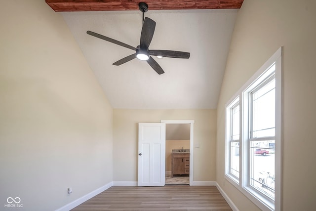 unfurnished bedroom with baseboards, a ceiling fan, light wood-style flooring, and lofted ceiling