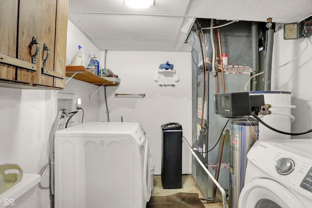 washroom with cabinet space, washing machine and clothes dryer, and water heater