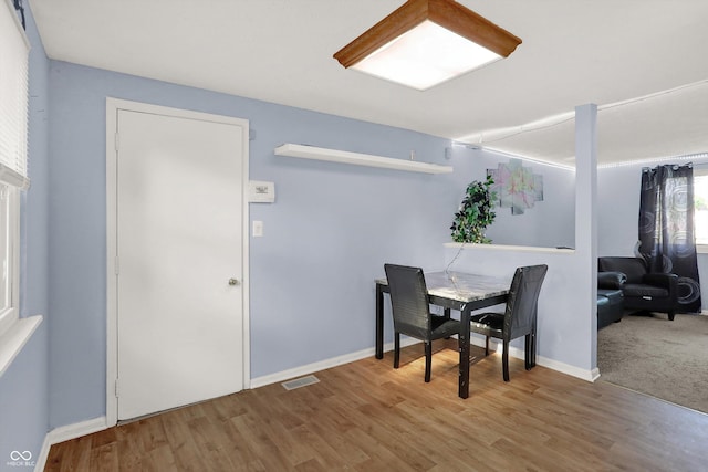 dining area featuring wood finished floors, baseboards, and visible vents