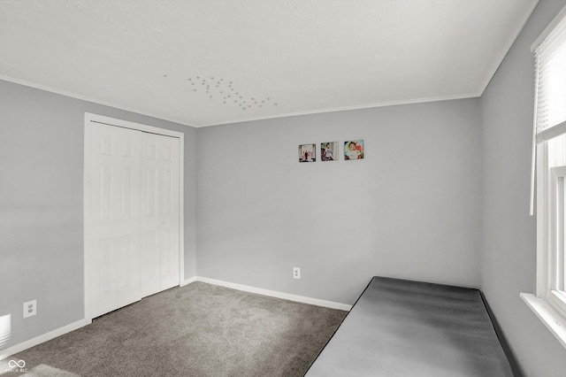 unfurnished room featuring crown molding, baseboards, and carpet floors