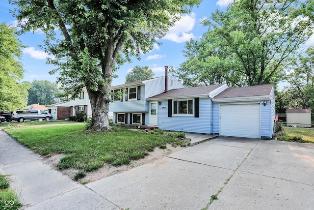 split level home with a garage, driveway, fence, and a front lawn