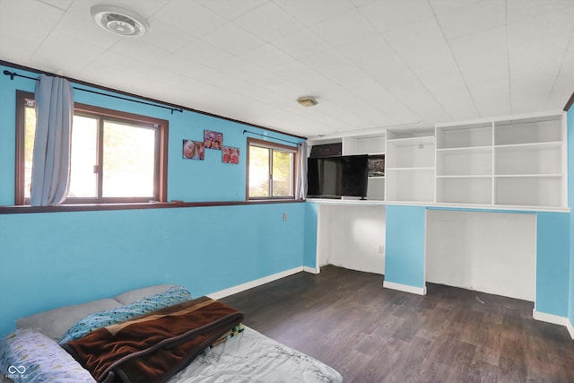 unfurnished bedroom featuring baseboards and dark wood finished floors